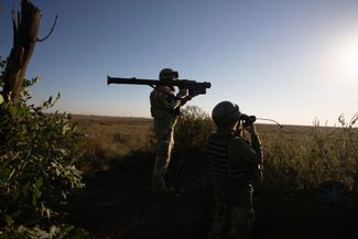 Украинские военнослужащие с позывными «Рыжий» и «Скелия» прицеливаются из зенитной ракеты на передовой под Клещеевкой