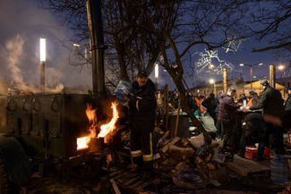 Volunteers feed newcomers outside the Lviv train station. March 3, 2022.