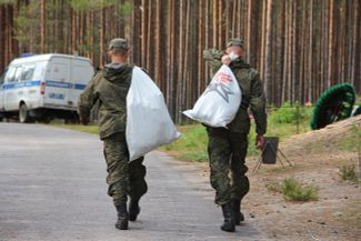 Soldiers remove bags filled with human remains recovered from the Sandarmokh forest, August 29, 2018