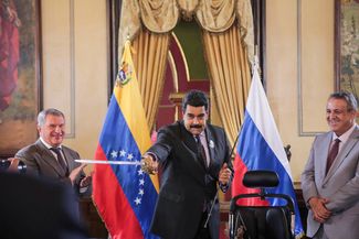 Venezuelan President Nicolás Maduro holds a replica of a sword that belonged to Venezuela’s national hero, Simon Bolivar, as Rosneft head Igor Sechin and Venezuelan Oil Minister and state oil company president Eulogio del Pino look on. Caracas, Venezuela; July 28, 2016