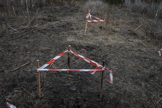 Спецподразделение Национальной полиции по разминированию во время операции помечает места, где были обнаружены противотанковые мины 