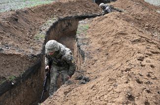 Украинский военный идет по траншее на передовой рядом с Бахмутом. Командующий Сухопутными войсками ВСУ Александр Сырский <a href="https://t.me/militarymediacenter/1663" rel="noopener noreferrer" target="_blank">утверждает</a>, что российские войска начали применять под Бахмутом тактику выжженной земли. «Уничтожает здания и позиции ударами авиации и огнем артиллерии. Оборона Бахмута продолжается. Ситуация сложная, но контролируемая», — уточнил Сырский. Спикер Восточной группировки войск ВСУ Сергей Череватый <a href="https://www.rbc.ua/ukr/news/chomu-rosiyani-pochali-kidati-bahmut-elitni-1681034854.html" rel="noopener noreferrer" target="_blank">заявил</a>, что российское командование начало перебрасывать под Бахмут элитные подразделения войск, в том числе десантников. Минобороны РФ не комментировало эти данные