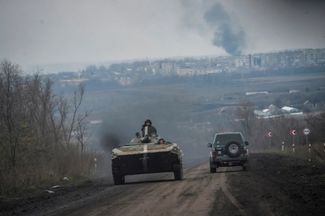 Украинская БМП в окрестностях Бахмута. На заднем плане виден дым от пожара в результате боев и обстрелов жилых кварталов