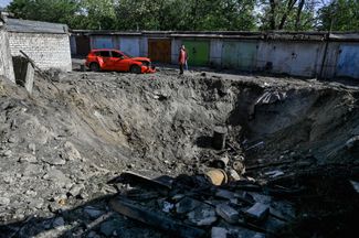 Воронка после российского обстрела в гаражном комплексе в Запорожье. 8 мая 2024 года